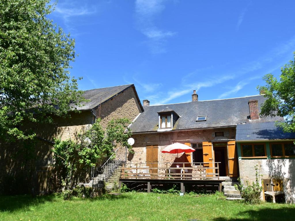 a house with a deck with a red umbrella at Bright holiday home in Gascony with garden in Gâcogne