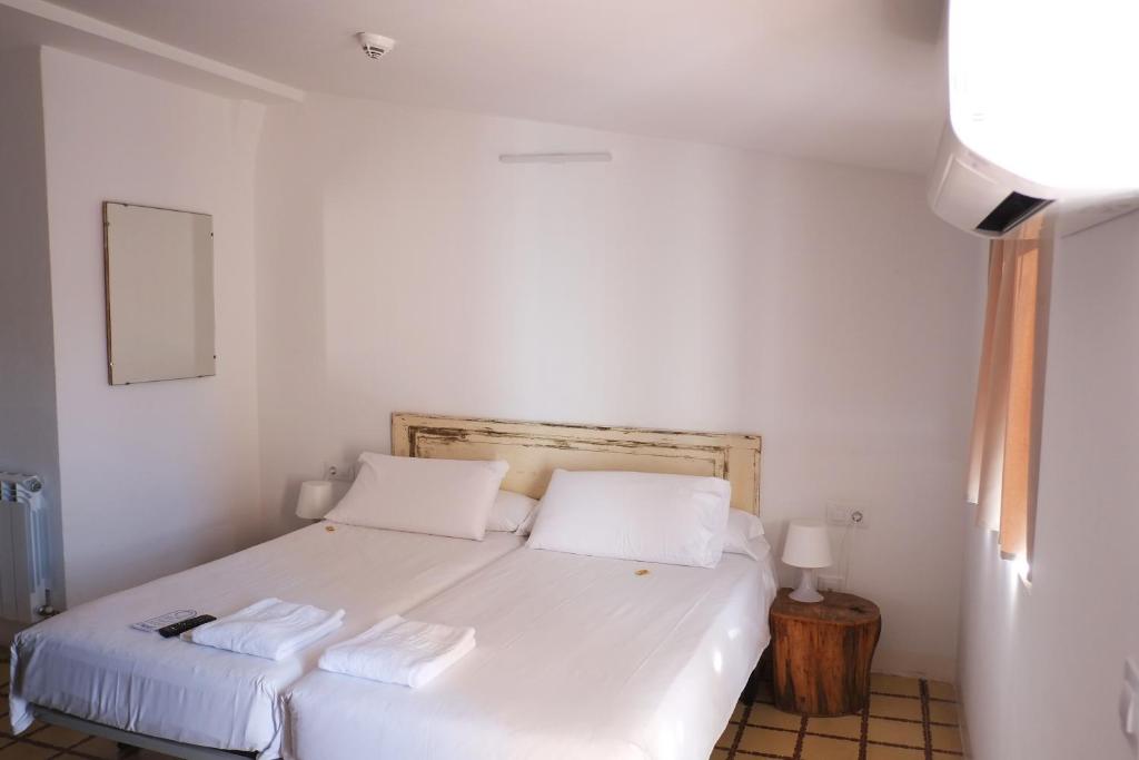1 dormitorio con 1 cama blanca y 2 almohadas en Pigal, en Tarragona