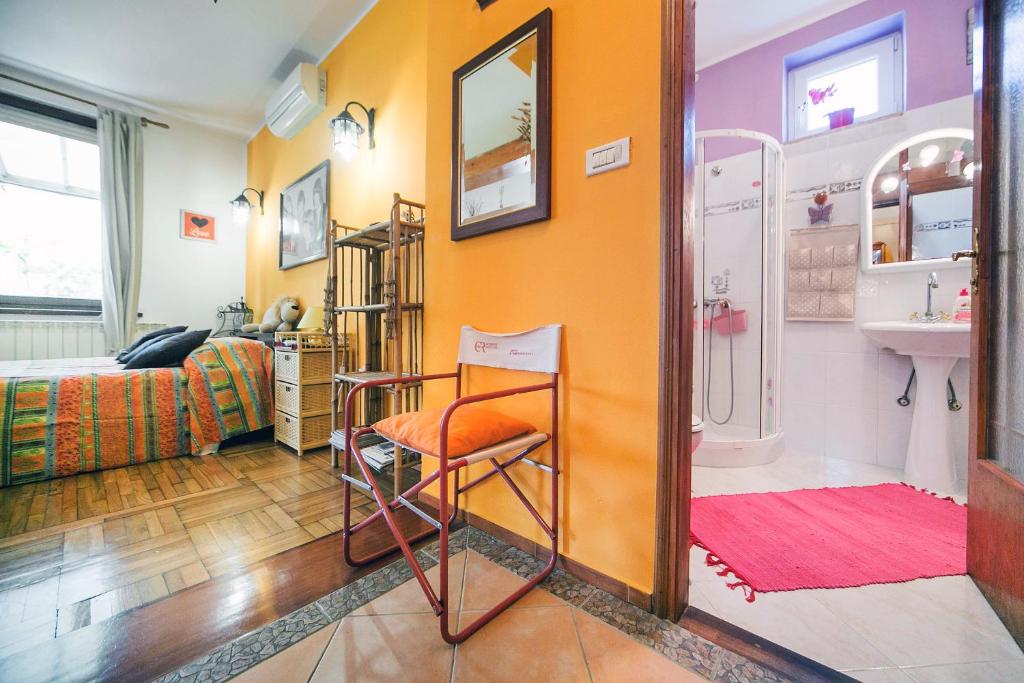 a bathroom with a sink and a chair in a room at Apartments Baredi in Izola