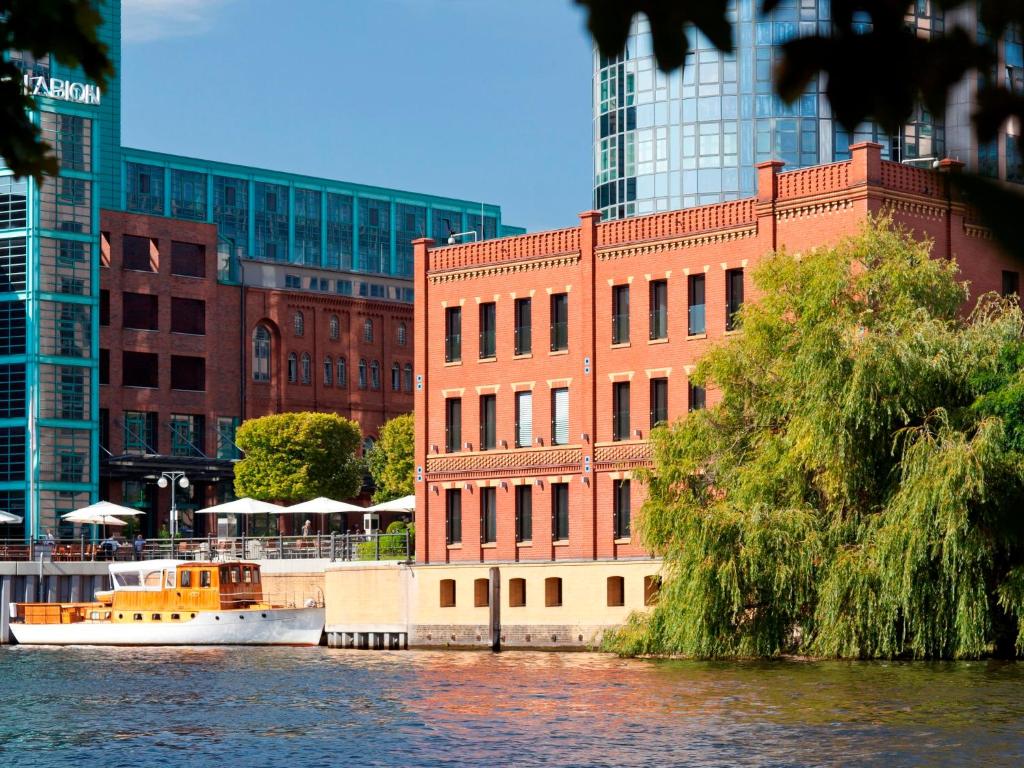 a boat in the water in front of a building at ABION Villa Suites in Berlin