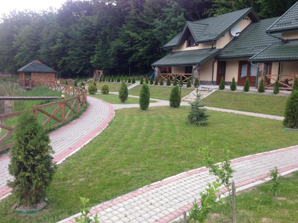a garden with a house and trees and a path at Поляна Купіль in Polyana