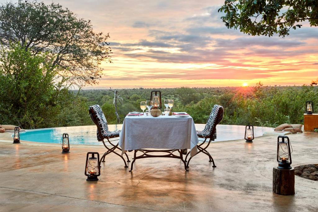 a table with wine glasses on it with a view at Geiger's Camp in Timbavati Game Reserve by NEWMARK in Timbavati Game Reserve
