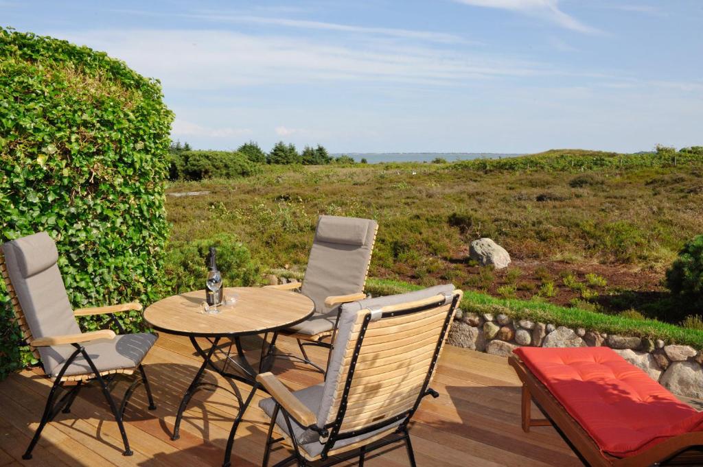 eine Terrasse mit einem Tisch und Stühlen auf einer Holzterrasse in der Unterkunft Ferienwohnung Sönshörn in Munkmarsch