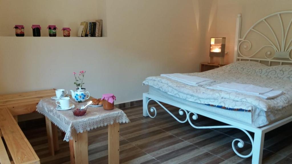 a bedroom with a bed and a table with a table sidx sidx sidx at Arami Guest House in Dilijan