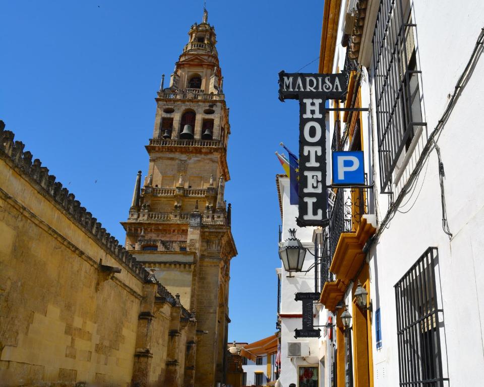 een hoog gebouw met een klokkentoren op de achtergrond bij Hotel Marisa in Córdoba