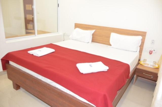 1 dormitorio con 1 cama grande y 2 toallas. en Raya's Inn, en Kumbakonam