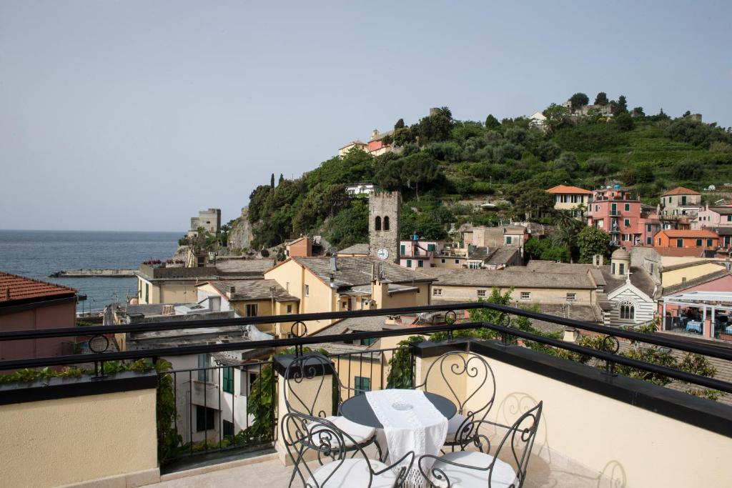 a man sitting on a balcony overlooking a city at Hotel La Colonnina in Monterosso al Mare