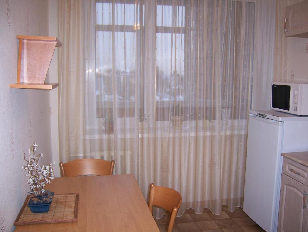 ニジニ・ノヴゴロドにあるApartment on Pochainskayaのキッチン(テーブル付)、窓(電子レンジ付)