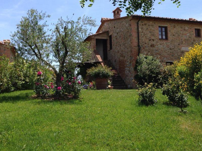una casa con un jardín con flores delante en La Casa del Tatone, en Gambassi Terme