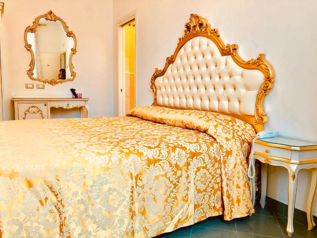 a bedroom with a large bed and a mirror at Hotel Marte in Venice