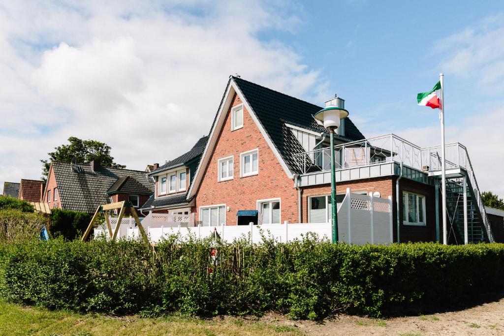 uma casa com uma bandeira em frente em Haus Nordland em Langeoog