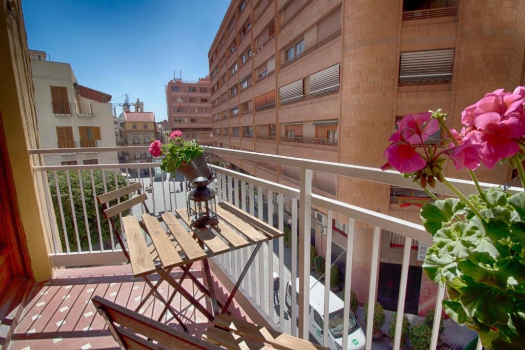 Un balcón con una mesa y flores. en Apartamento Rivera#2, en Alicante