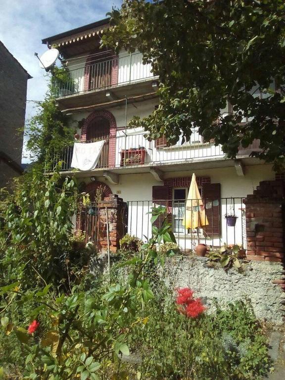 ceglany dom z balkonem i patio w obiekcie Il Giardino dei Merli w mieście Bussoleno