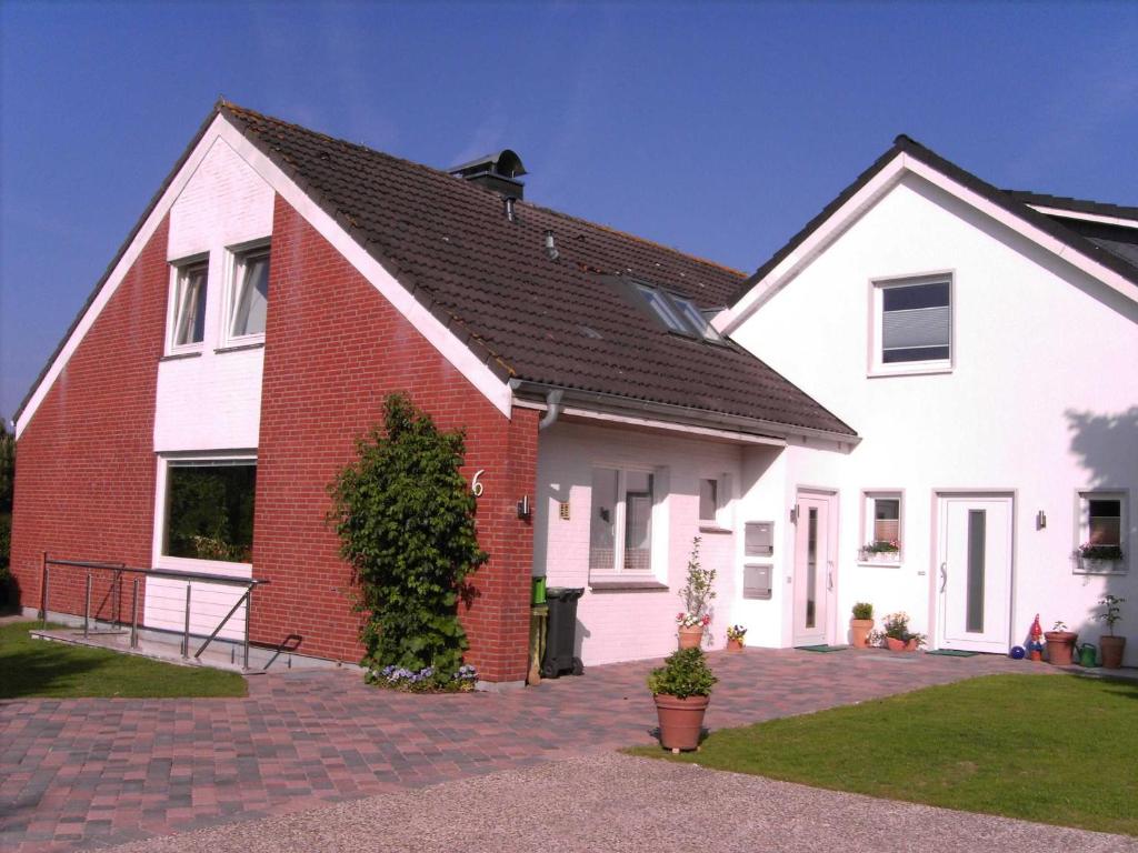 a white and red house with a brick at Ferienwohnung Maren Graf in Neustadt in Holstein