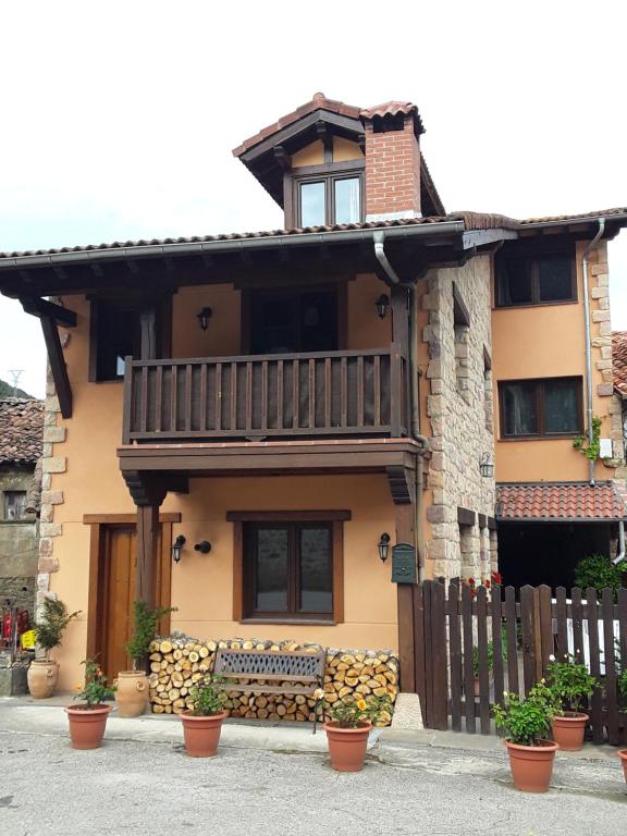 una casa con balcone e panca di fronte ad essa di La Fragua de La Vega Estudios a La Vega