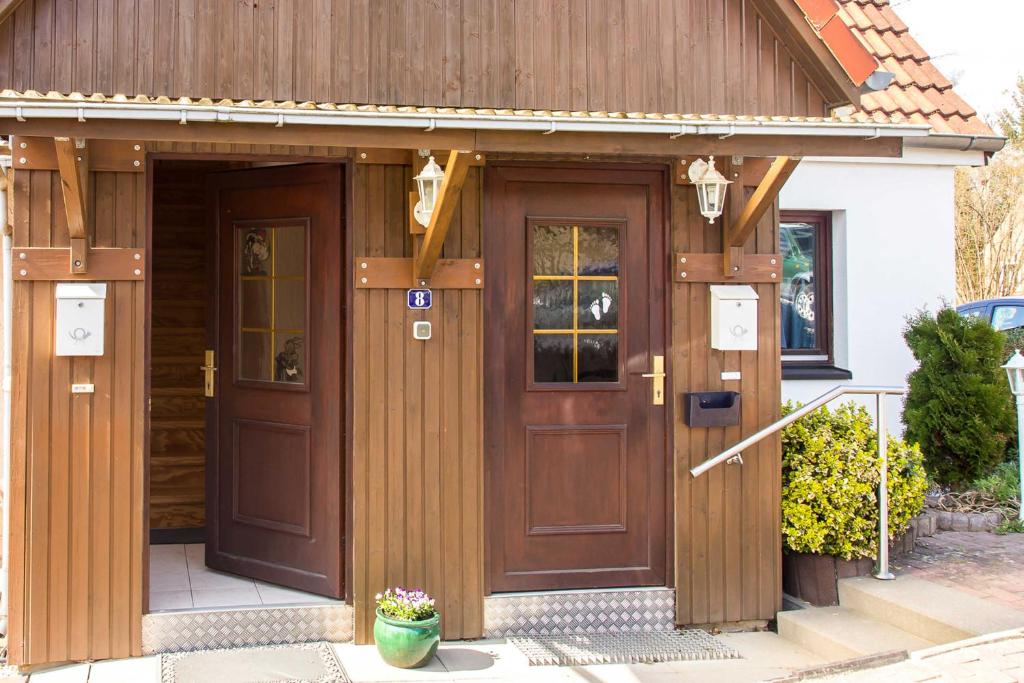 une maison avec une grande porte en bois dans l'établissement Ferienwohnung Lampe, à Neustadt in Holstein