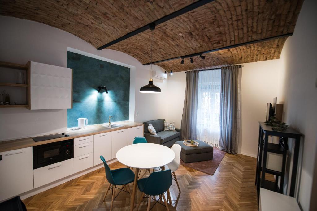 a kitchen and living room with a table and chairs at City Apartments Green Oasis in Zagreb