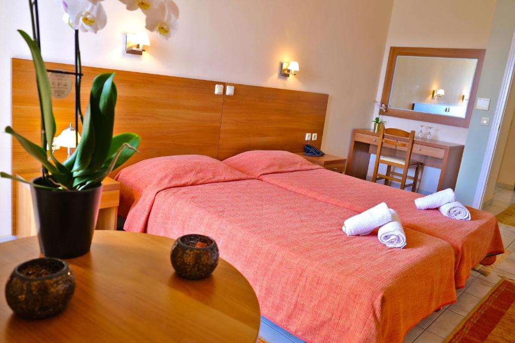 Un dormitorio con 2 camas y una mesa con toallas. en Sunset Hotel, en Xiropigado