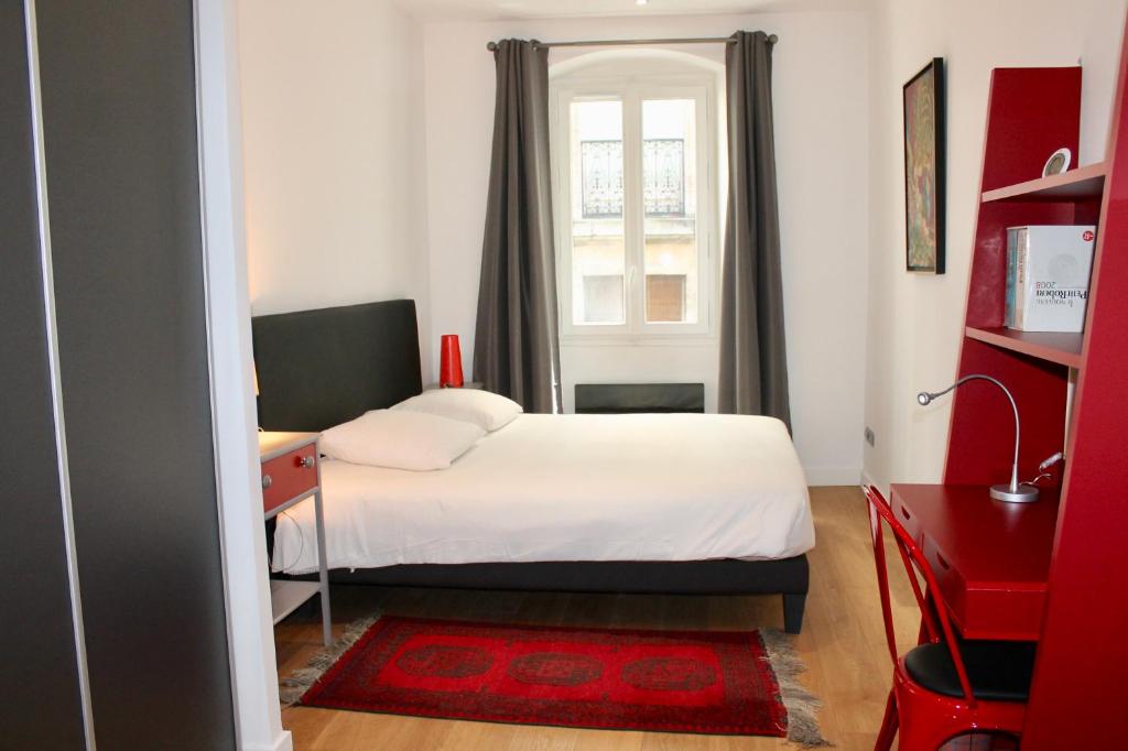 a bedroom with a bed and a desk and a window at LE CONFIDENTIEL by Cocoonr in Bordeaux
