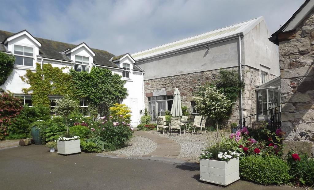 dom z patio i kwiatami przed nim w obiekcie River View Knockraich Farm w mieście Fintry