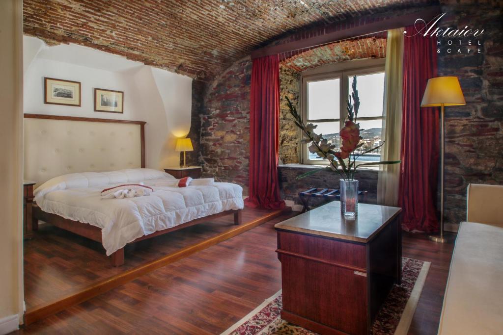 Hotel Aktaion Syros في إرموبولّي: غرفة نوم بسرير وجدار من الطوب