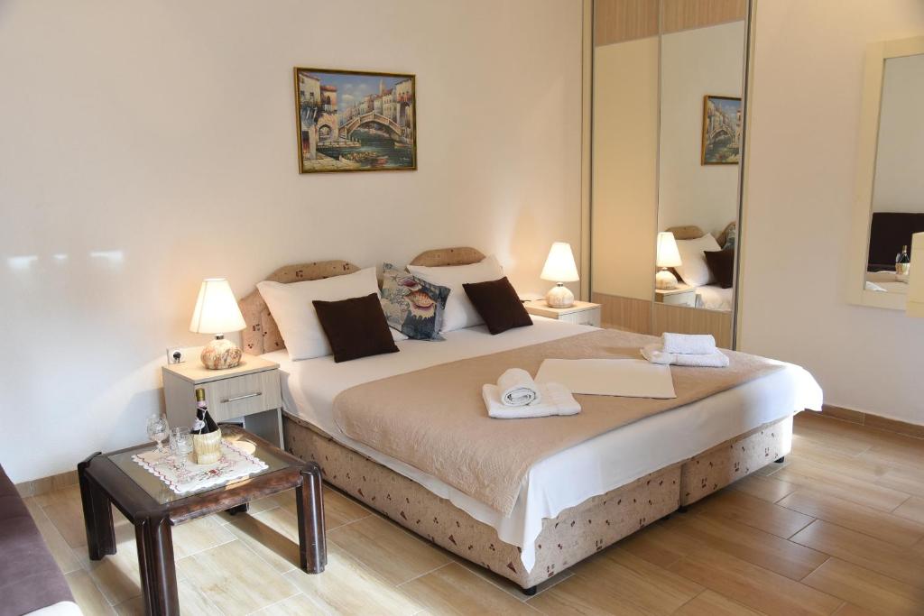 ein Schlafzimmer mit einem großen Bett und einem Spiegel in der Unterkunft Apartments & Rooms Jelka in Kotor