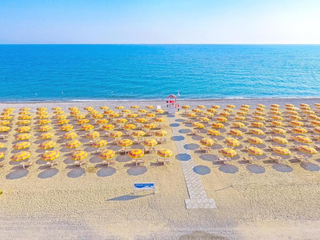 een groep parasols en stoelen op een strand bij Futura Club Itaca Nausicaa in Rossano