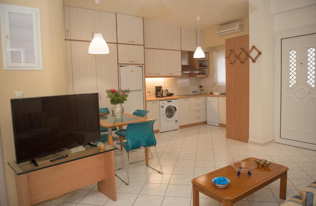 a living room with a television and a kitchen at Comfi apartment Kleio in Heraklio Town