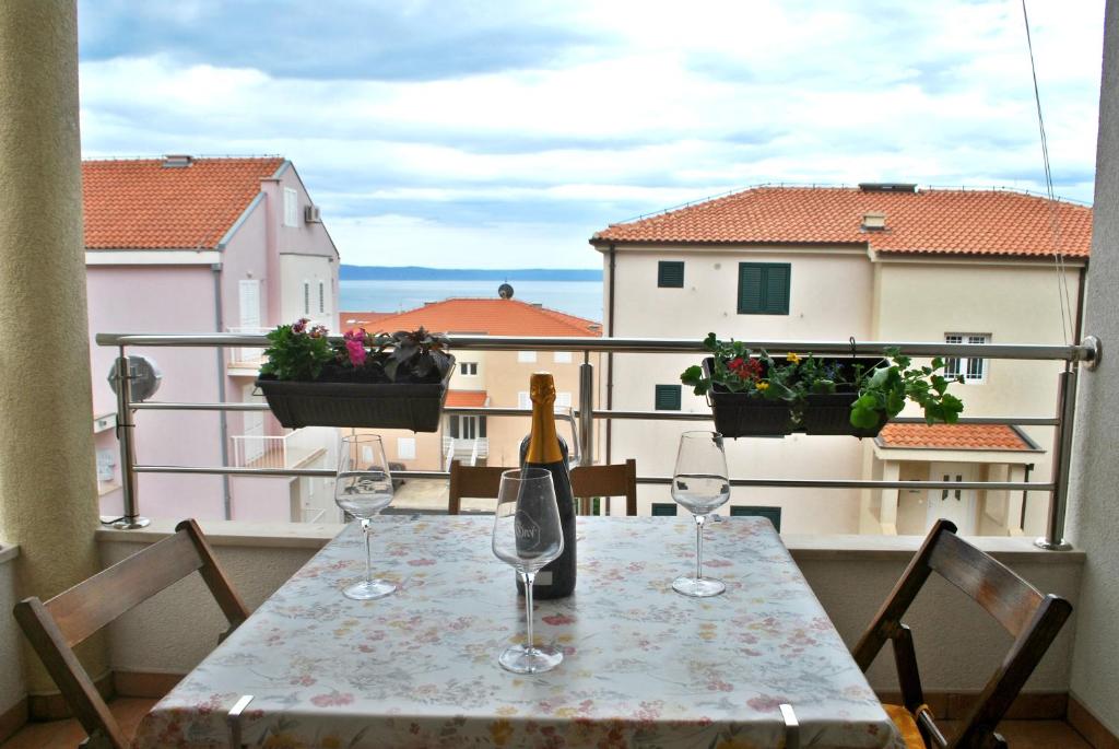 a table with wine glasses sitting on top of a balcony at Apartment Dalmatia in Makarska