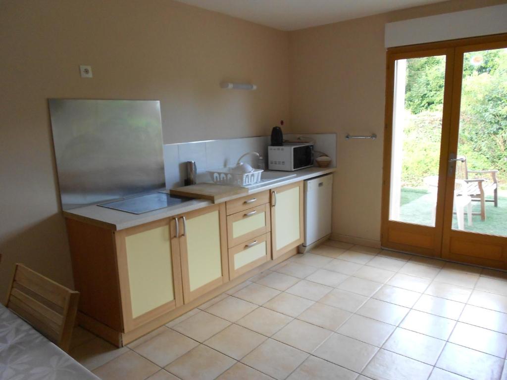 eine Küche mit einer Theke mit einer Mikrowelle und einem Fenster in der Unterkunft gîte de Courcelette in Courcelette
