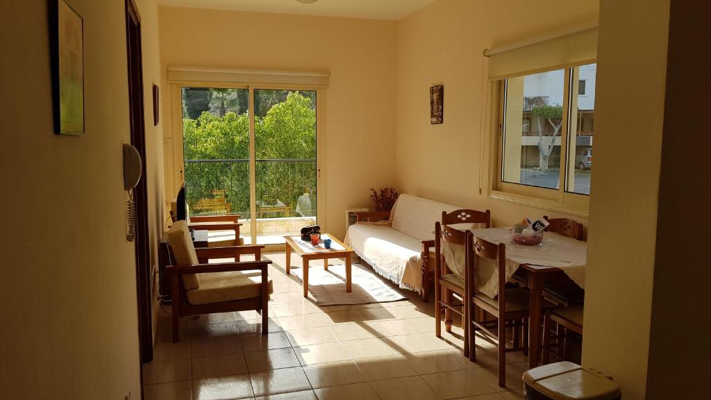 uma sala de estar com uma cama, uma mesa e cadeiras em Lazaros Pissouri Apartments em Pissouri