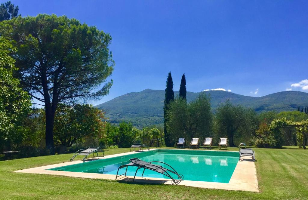 una piscina en un patio con montañas al fondo en Magnolia House, en Cetona