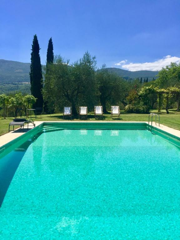 - une grande piscine avec 2 chaises dans la cour dans l'établissement Magnolia House, à Cetona