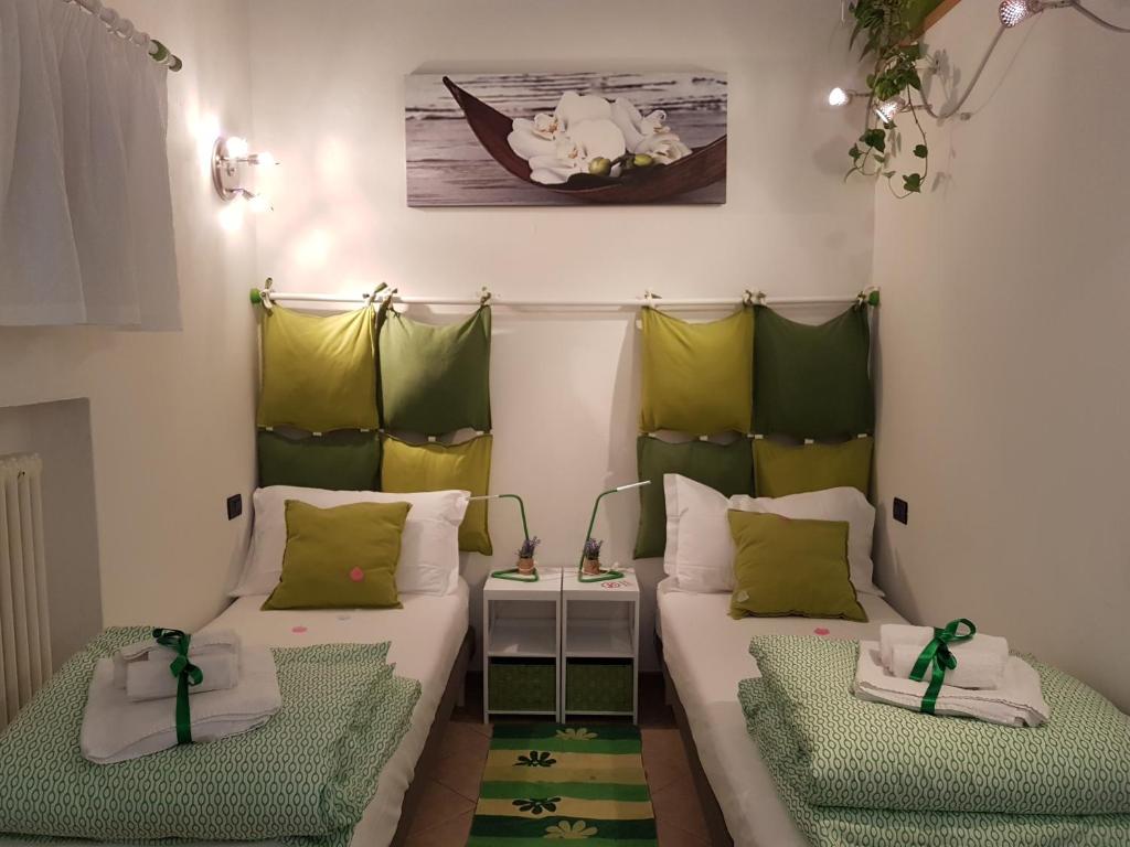 ボローニャにあるAppartamento Fico Bologna Fieraの緑と白の枕が備わる客室内のベッド2台