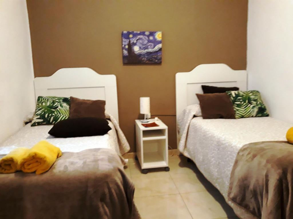 コルドバにあるApartamento Centro PARKING GRATISのベッドルーム1室(ベッド2台付)が備わります。ベッドの上に黄色いぬいぐるみが飾られています。