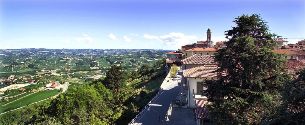 a building on a hill with a view of a city at Rocche Costamagna Art Suites in La Morra