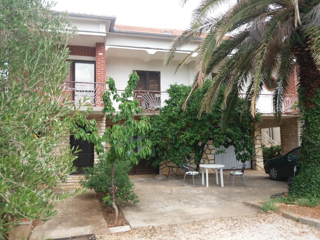 ein Haus mit einem Tisch und Stühlen im Innenhof in der Unterkunft Apartman Zlatko in Zadar