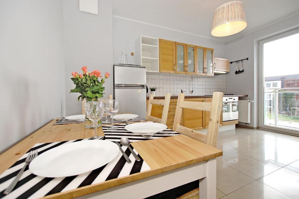 a kitchen with a wooden table with plates on it at House Managers - Galeria in Gdańsk