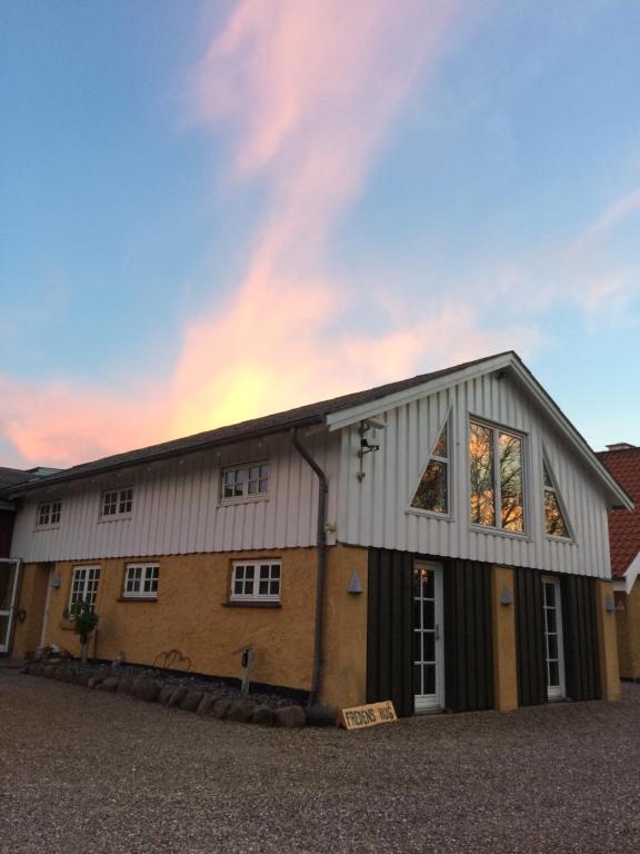 une grange avec un bâtiment avec un ciel dans l'établissement Rainbows End B&B, à Sorø