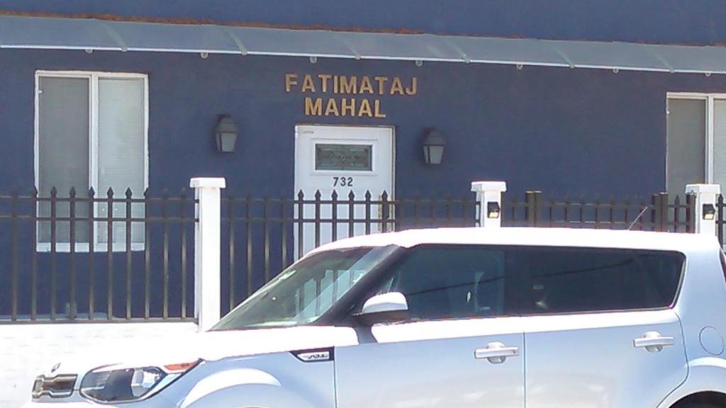 une voiture blanche garée devant un bâtiment dans l'établissement Fatimataj Mahal, à Miami