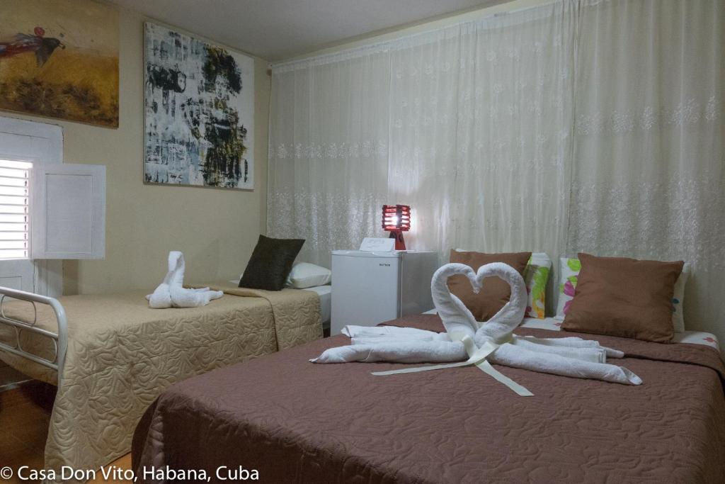 a room with two beds with a heart made out of towels at Casa Don Vito in Havana