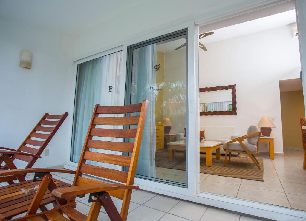 a room with sliding glass doors and rocking chairs at Marival Emotions Resort & Suites Riviera Nayarit by Mercure in Nuevo Vallarta