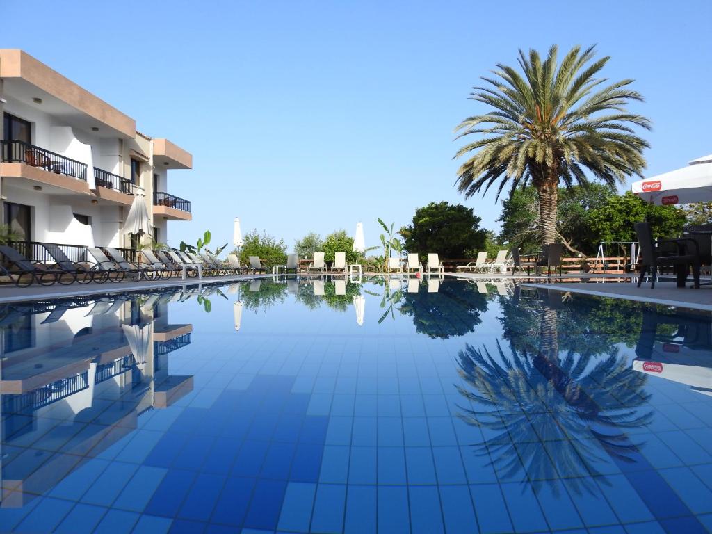 a swimming pool at a resort with a palm tree at Anna Hotel Apartments in Paphos City