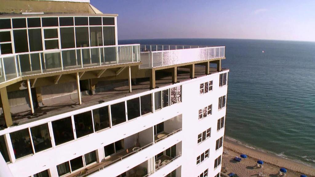 a building on the beach next to the ocean at Galt Ocean Drive Beach Condo in Fort Lauderdale