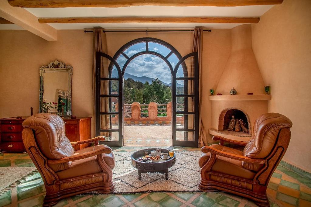 a living room with two chairs and a fireplace at Tizi N'Ouirgane in Marrakech