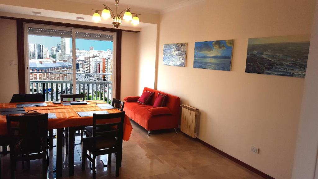 馬德普拉塔的住宿－ArielMardel，一间带桌子和红色沙发的用餐室