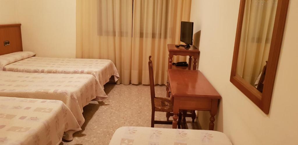 Postel nebo postele na pokoji v ubytování Hotel Reina Isabel