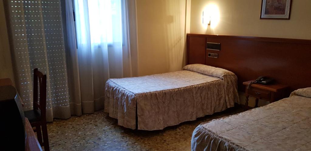 Postel nebo postele na pokoji v ubytování Hotel Reina Isabel