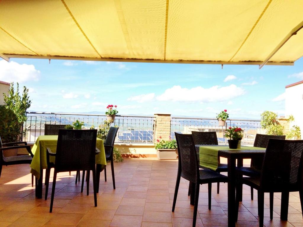 eine Terrasse mit Tischen und Stühlen und Meerblick in der Unterkunft B&B Bella Vista in Valguarnera Caropepe