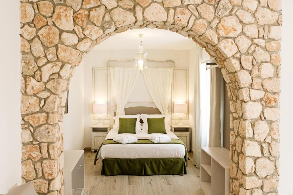 a bedroom with a bed with a stone wall at Suites La Posada De Pilar in Córdoba